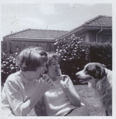 1966 Lois and Bev having an ice cream at the back of the family home in Fawkner while the dog looks on
